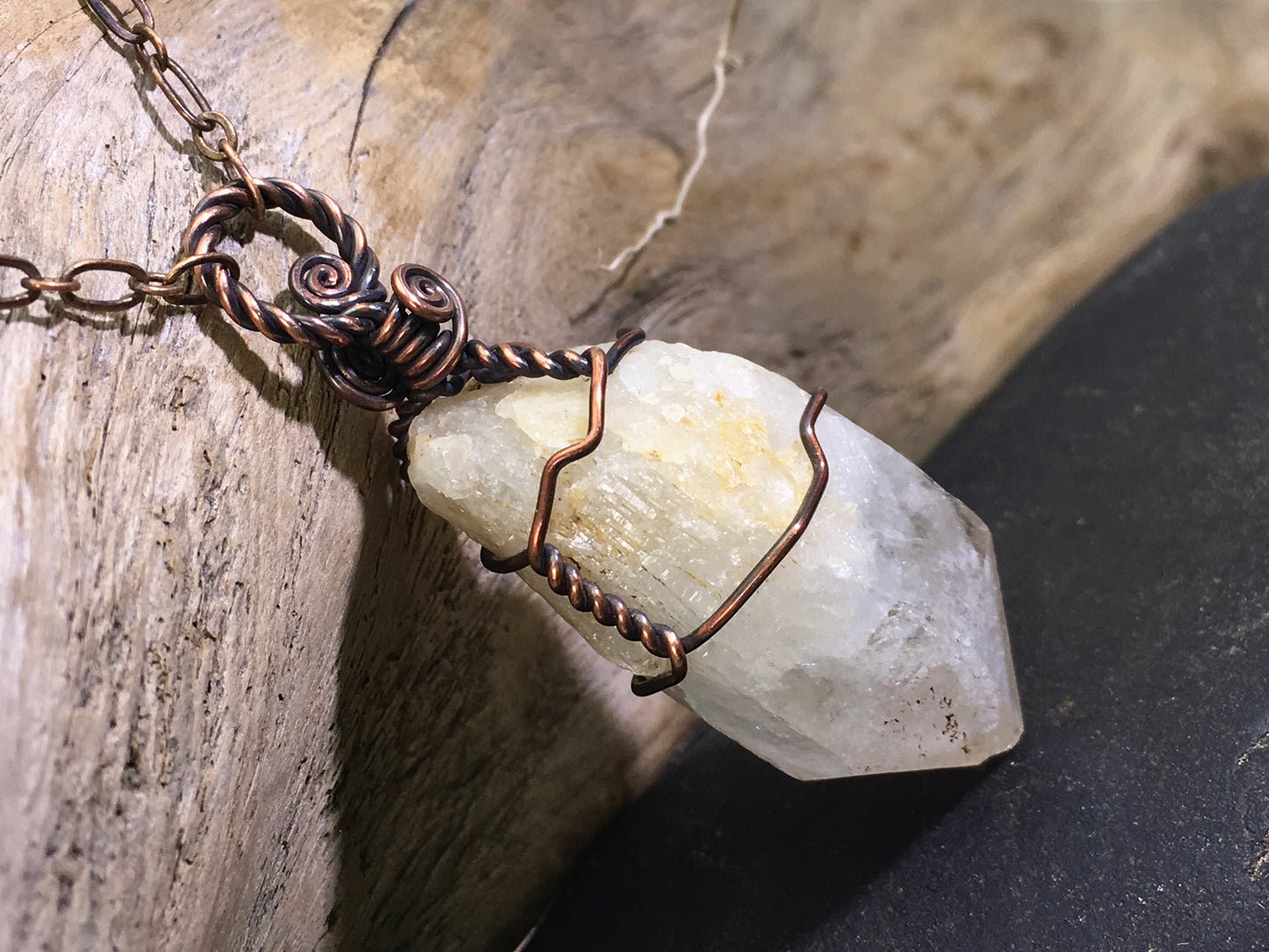 Side view of raw natural citrine crystal pendant featuring unheated phantom candle quartz wire wrapped in oxidized copper