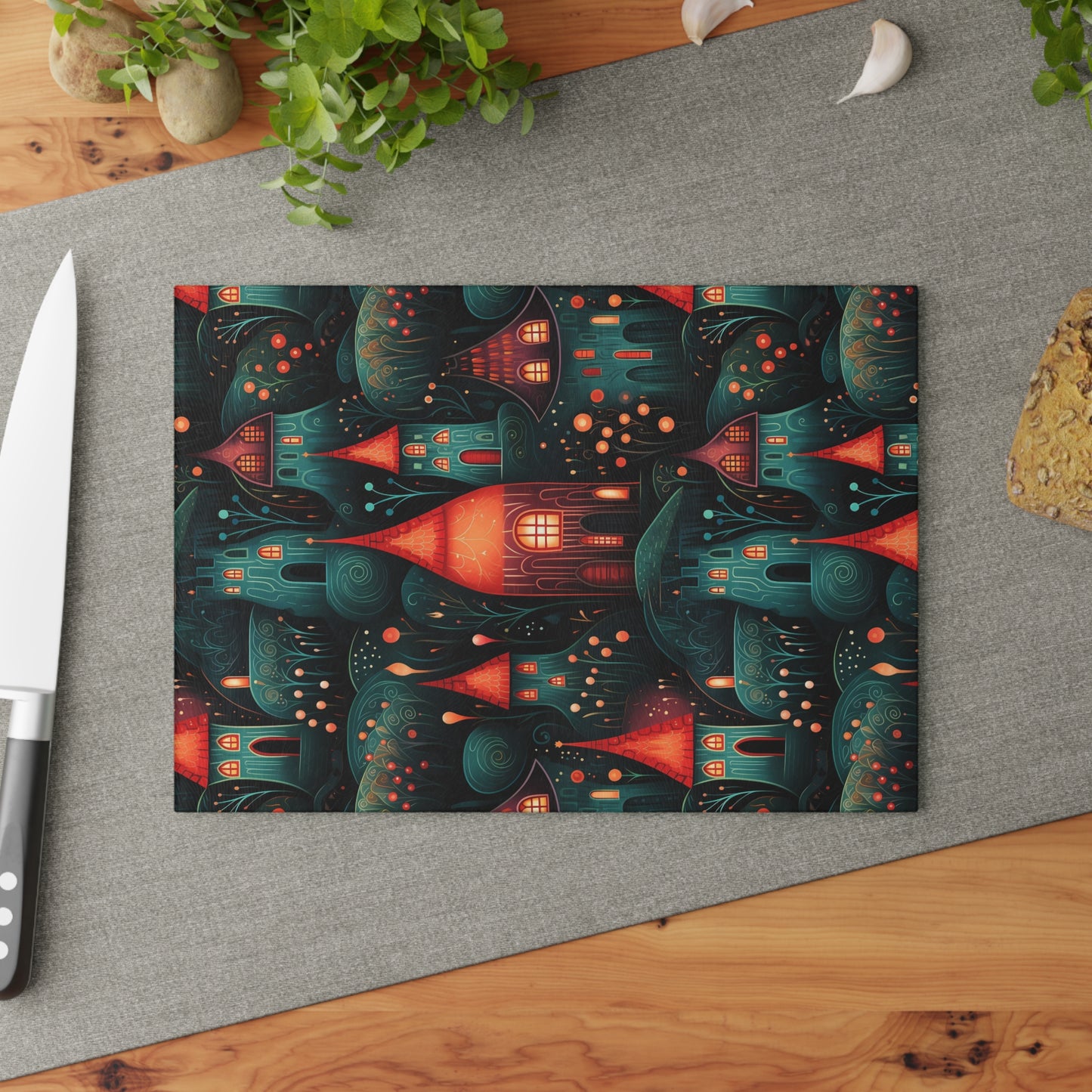 Whimsical autumn-themed glass cutting board styled on a kitchen counter with a knife and ingredients. The small size is shown, which is 8 x 11 inches.