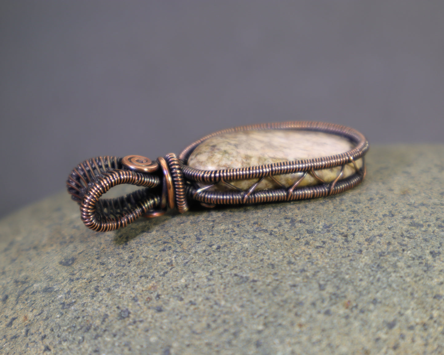 Neutral colored jasper pendant with artisan copper wirework