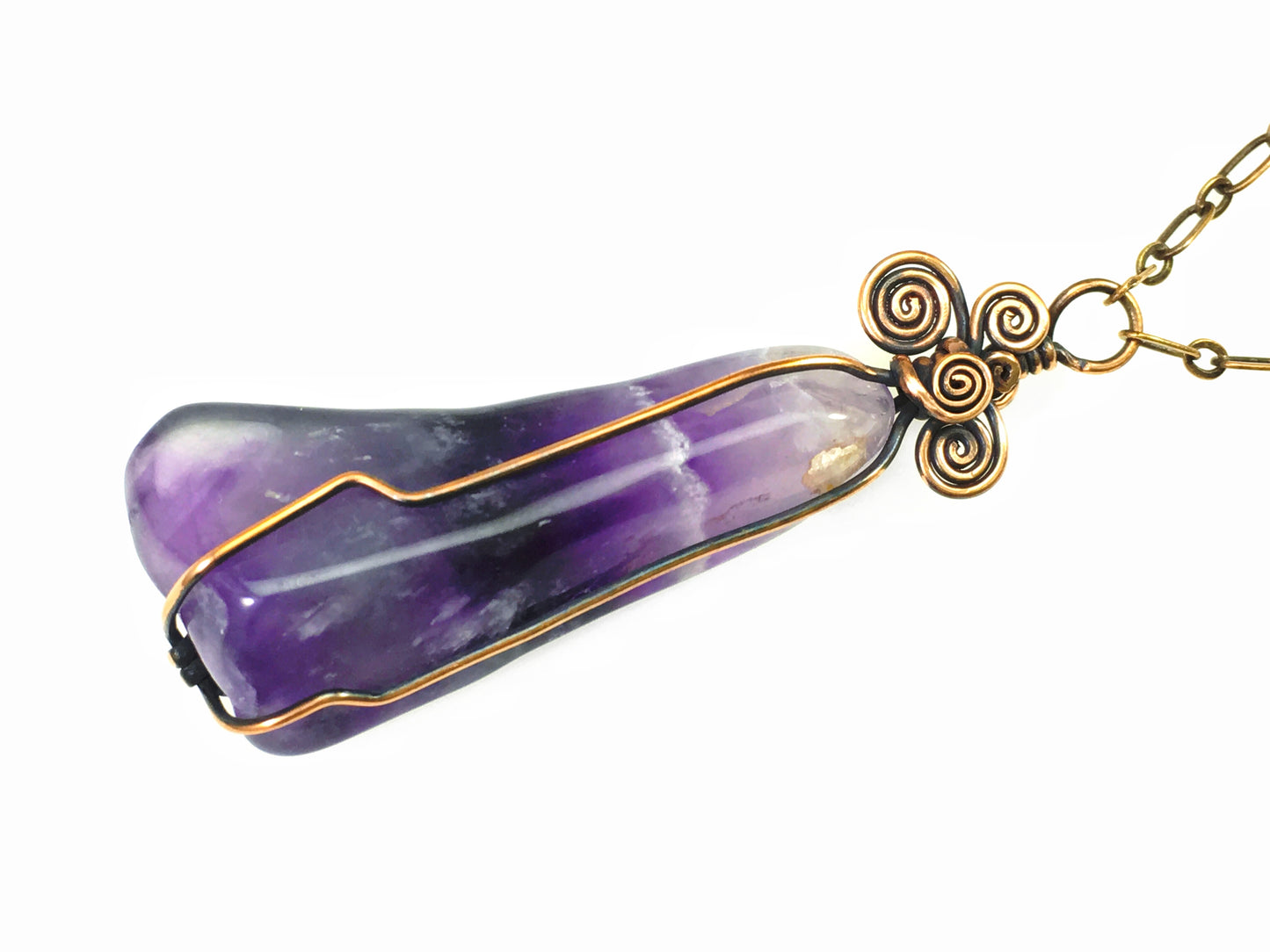 Back view of wire wrapped chevron amethyst pendant showing polished purple crystal patterns