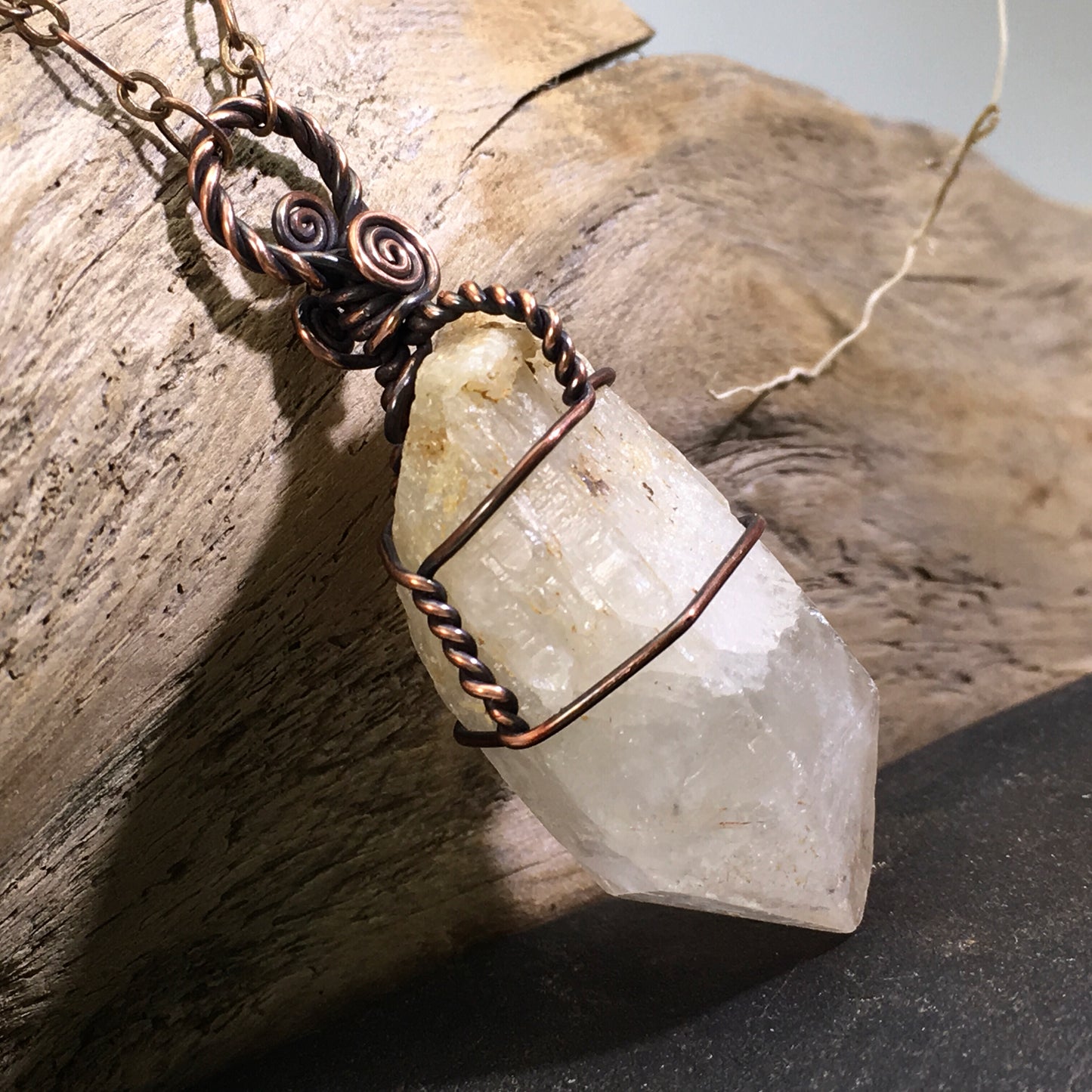 Side view of genuine natural citrine point necklace showing candle quartz growth and copper wire wrapping