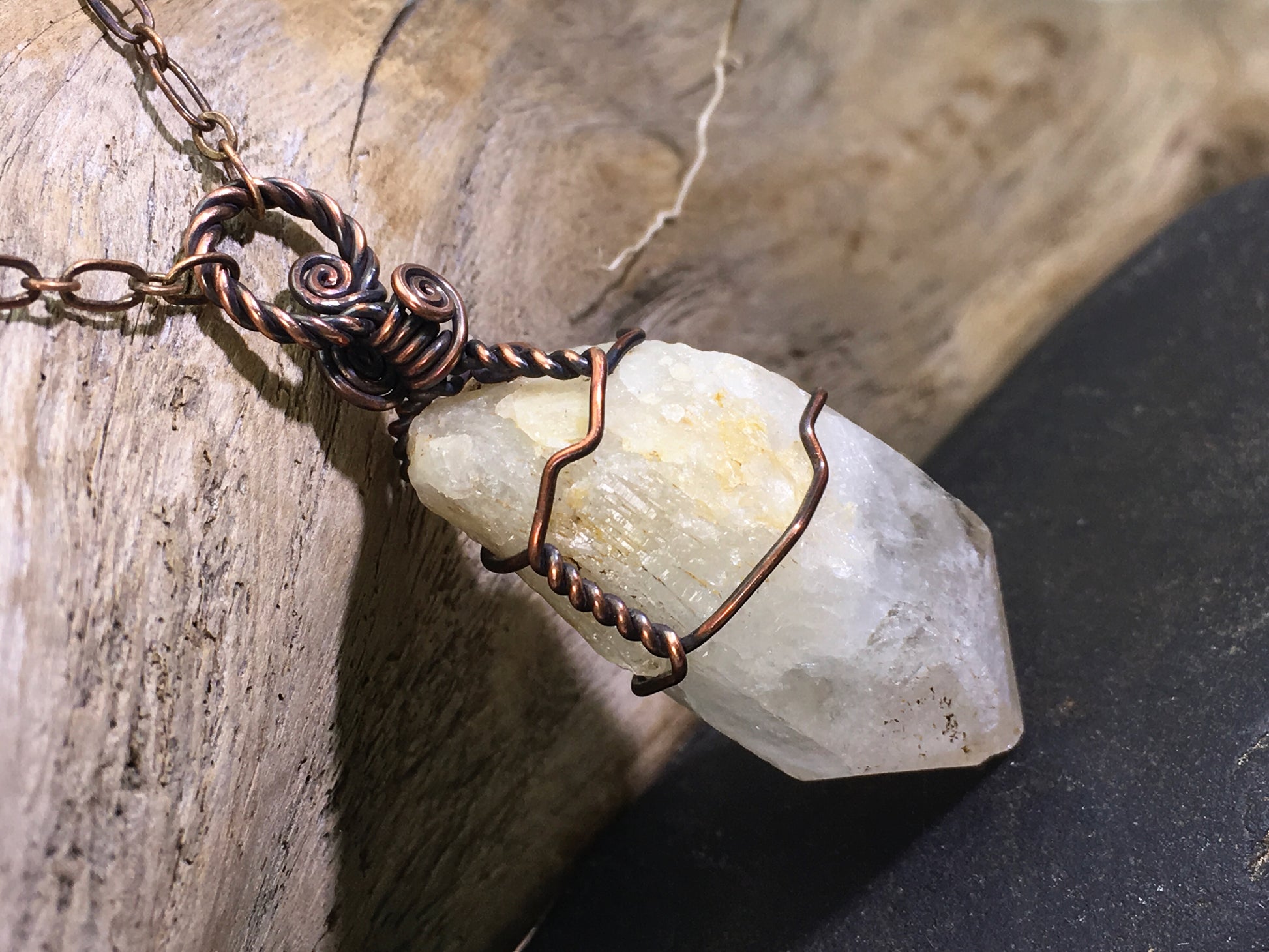 Side view of raw natural citrine crystal pendant featuring unheated phantom candle quartz wire wrapped in oxidized copper