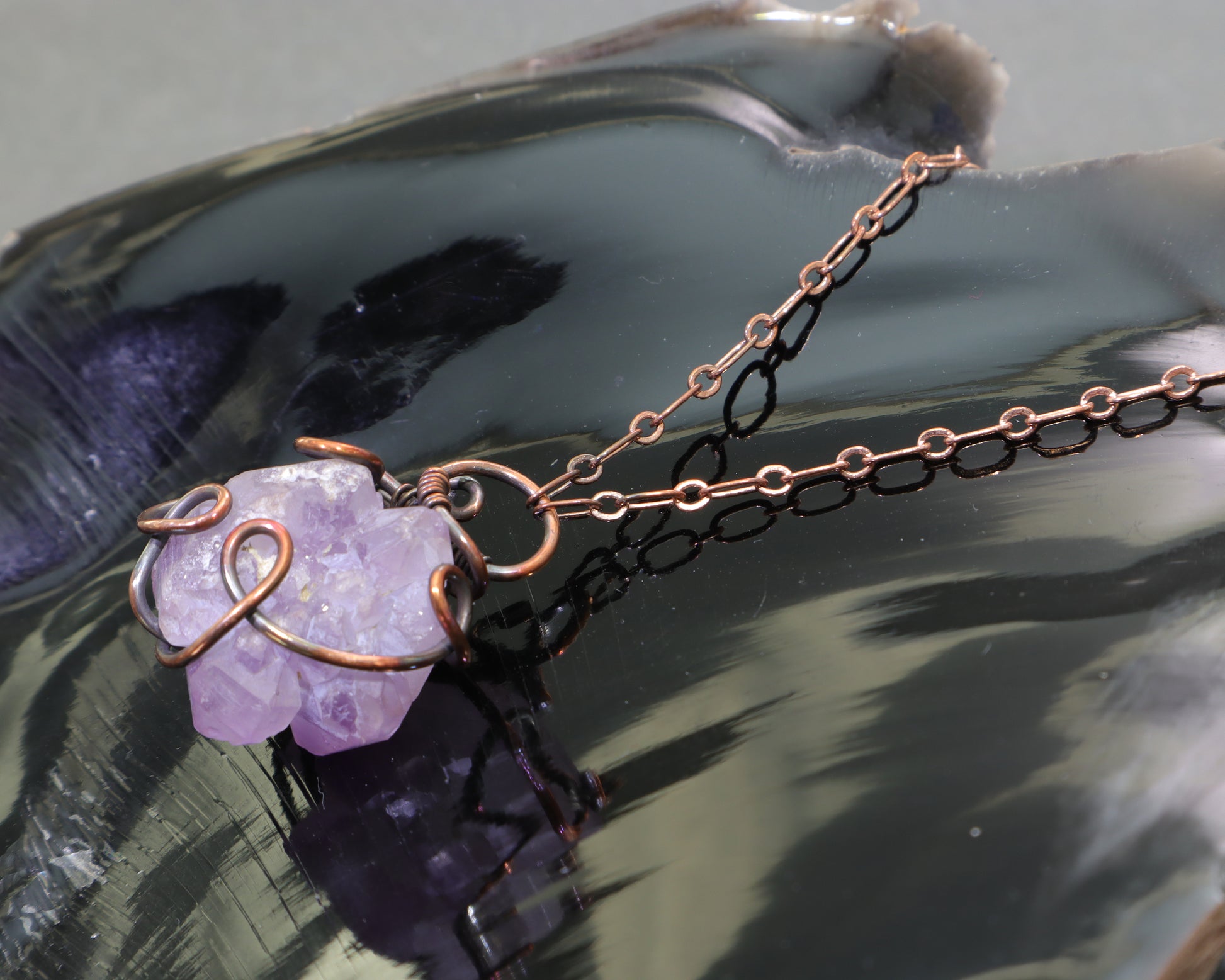 Elestial amethyst crystal pendant wire wrapped in oxidized copper on obsidian
