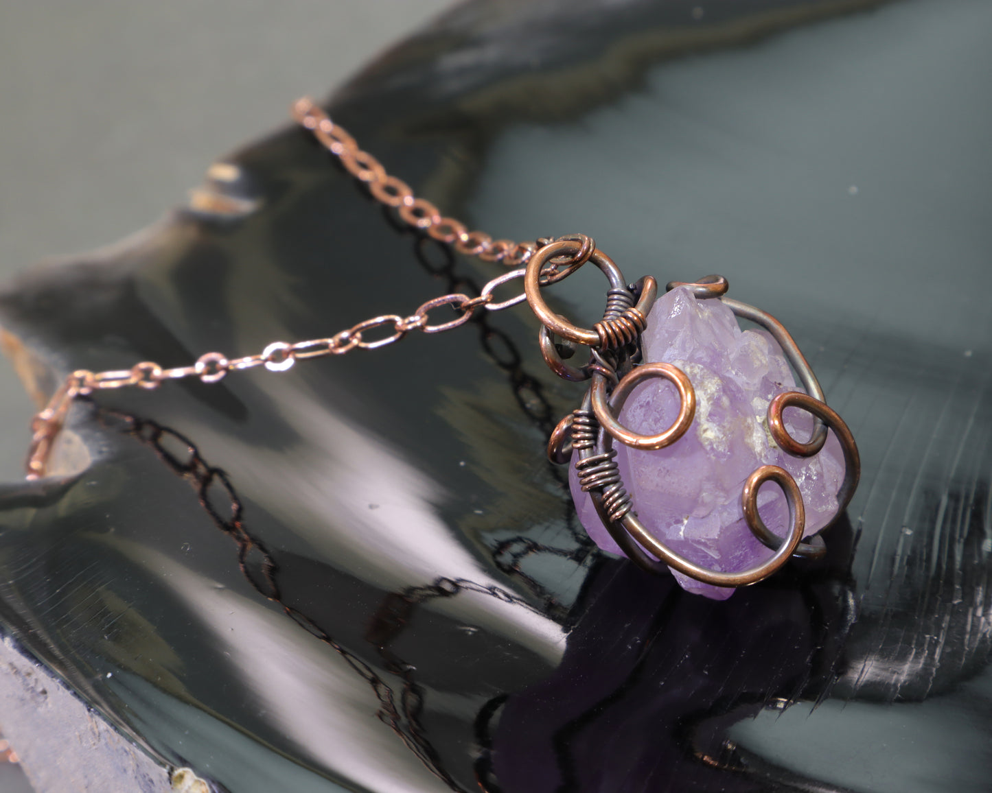 Close-up of elestial amethyst gemstone pendant handcrafted in antiqued copper