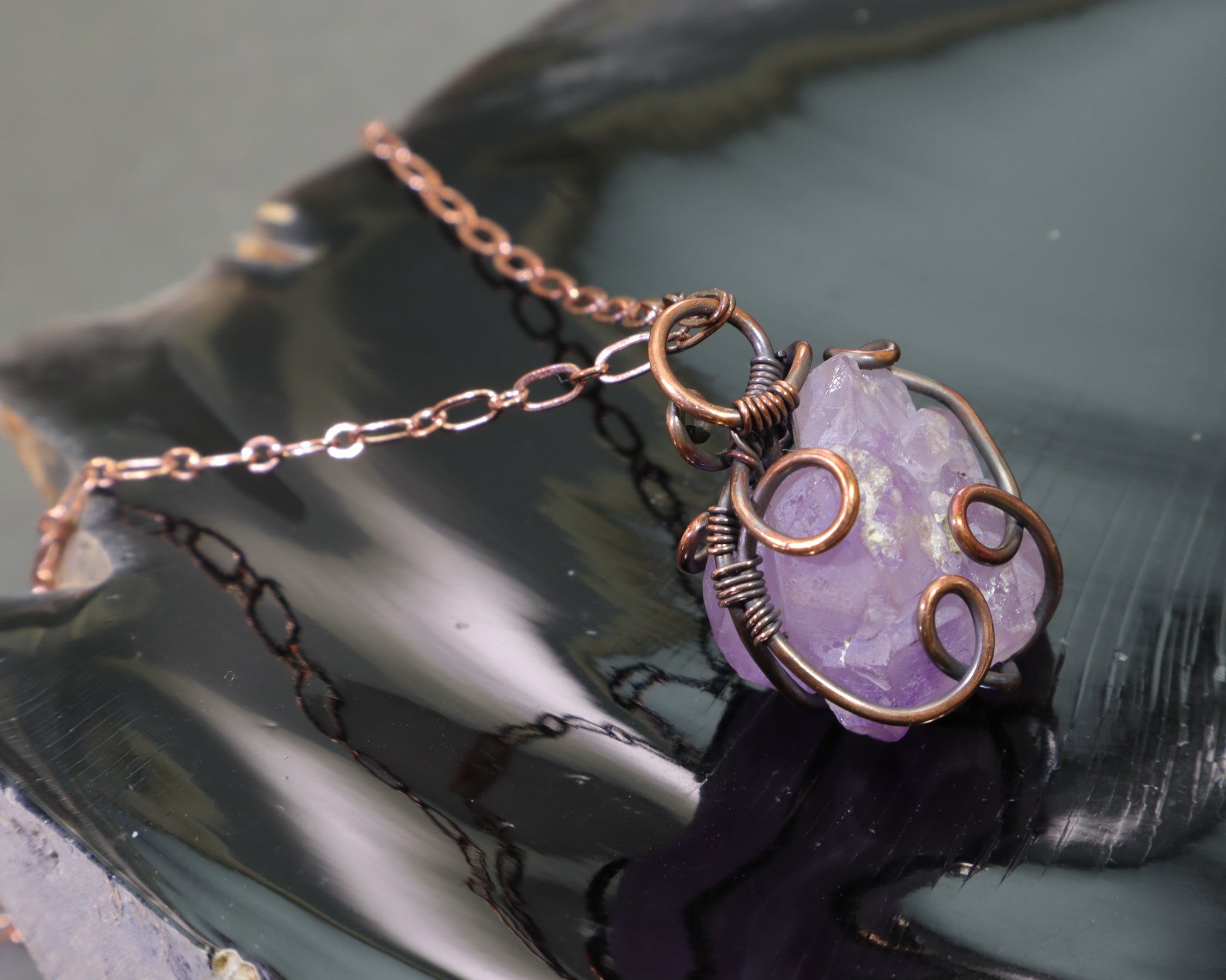 Close-up of elestial amethyst gemstone pendant handcrafted in antiqued copper