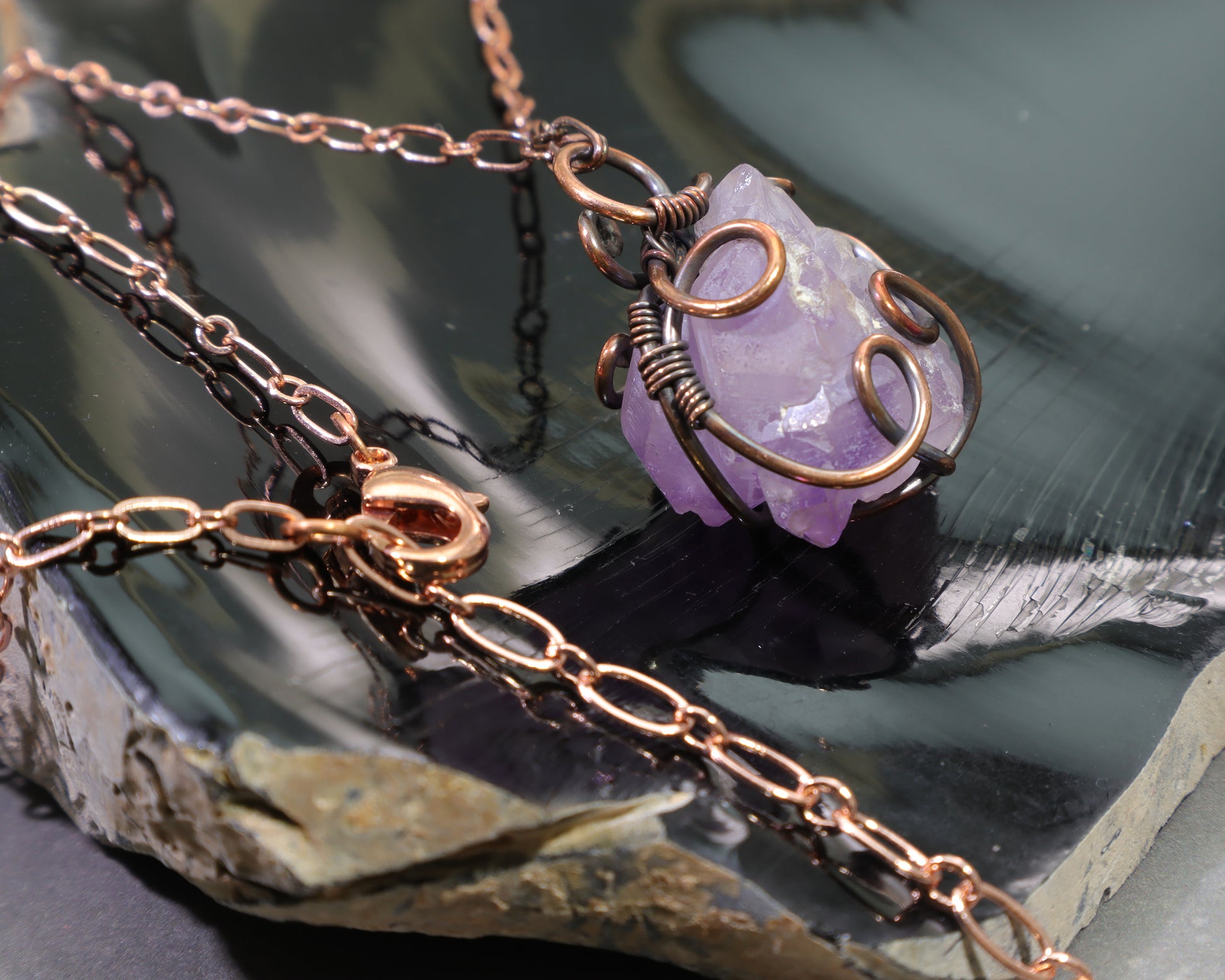 Close-up of elestial amethyst gemstone pendant handcrafted in antiqued copper