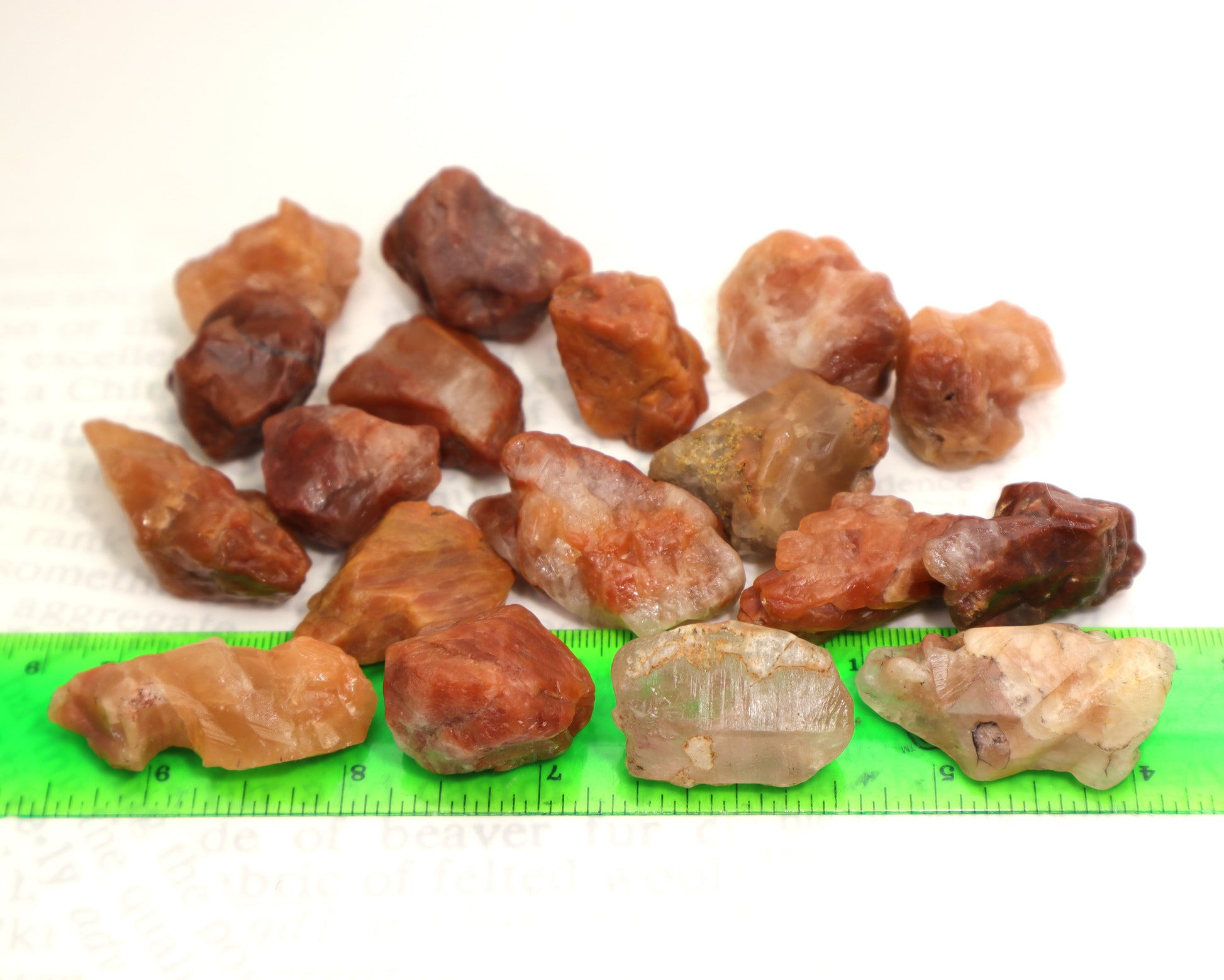 Collection of natural red phantom quartz mineral specimens on a ruler to show size