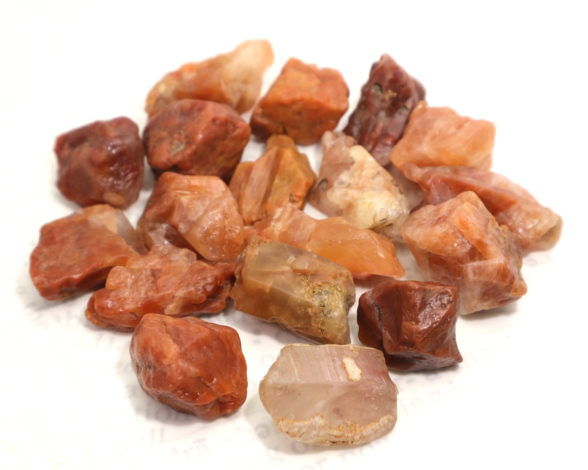 Assorted pink, red and orange raw quartz crystals from single lot