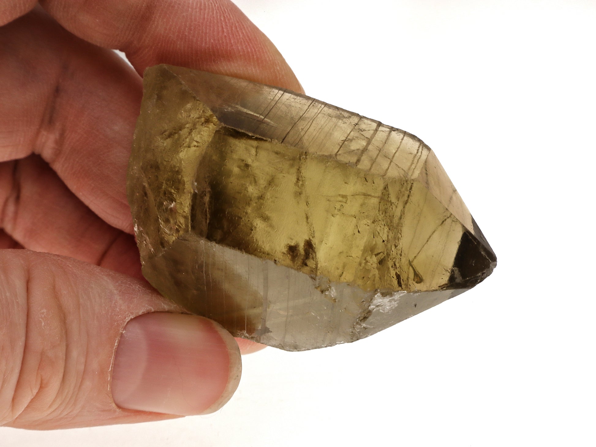Hand holding a raw citrine crystal showing stepped striation on the m-faces