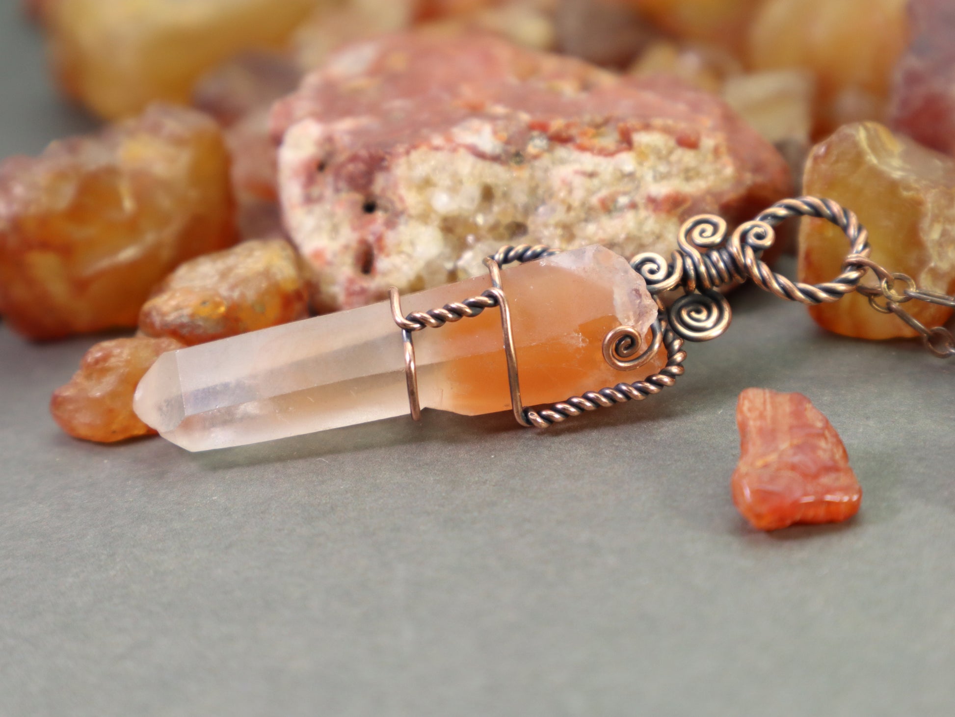 Papaya amphibole quartz crystal pendant with red-orange phantom inclusions