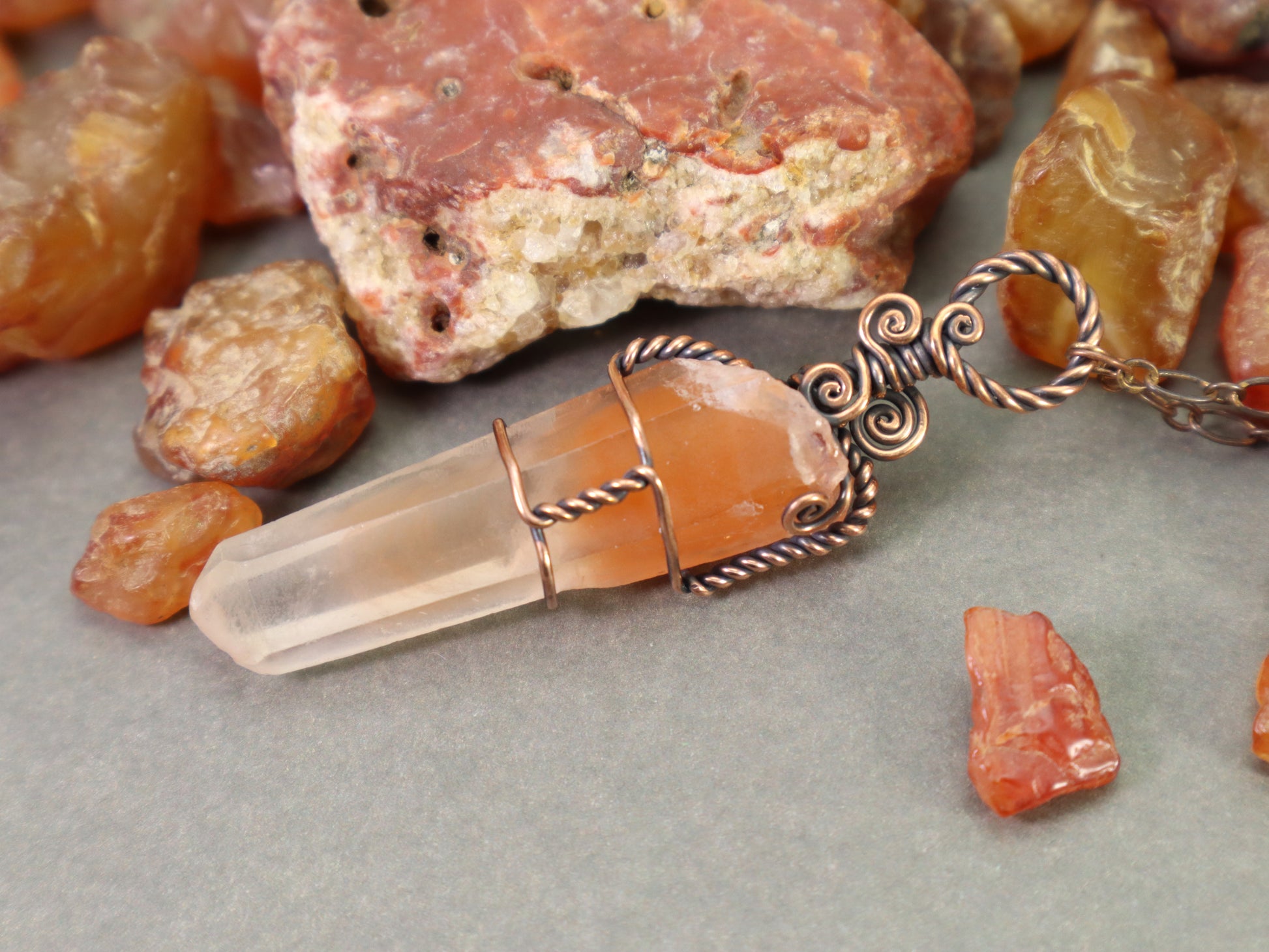 Wire-wrapped papaya amphibole quartz necklace with spiral copper bail