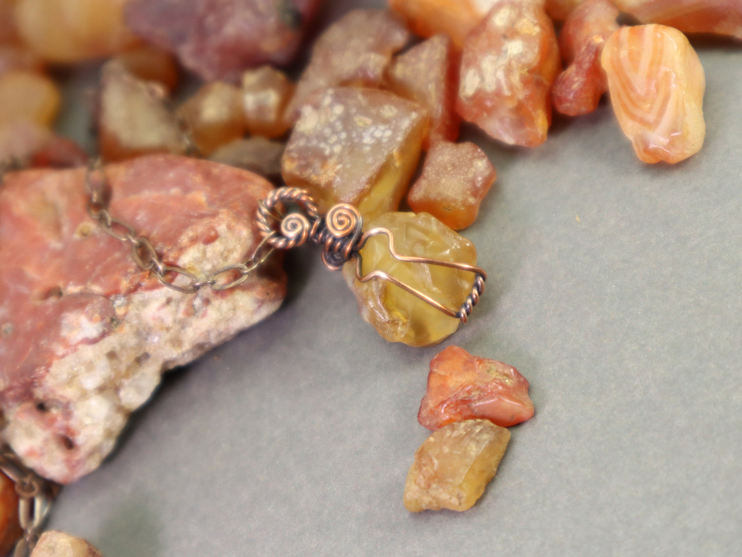 Artisan handmade carnelian pendant necklace photographed with agates and carnelians, all hand-collected by the artist in Washington State.