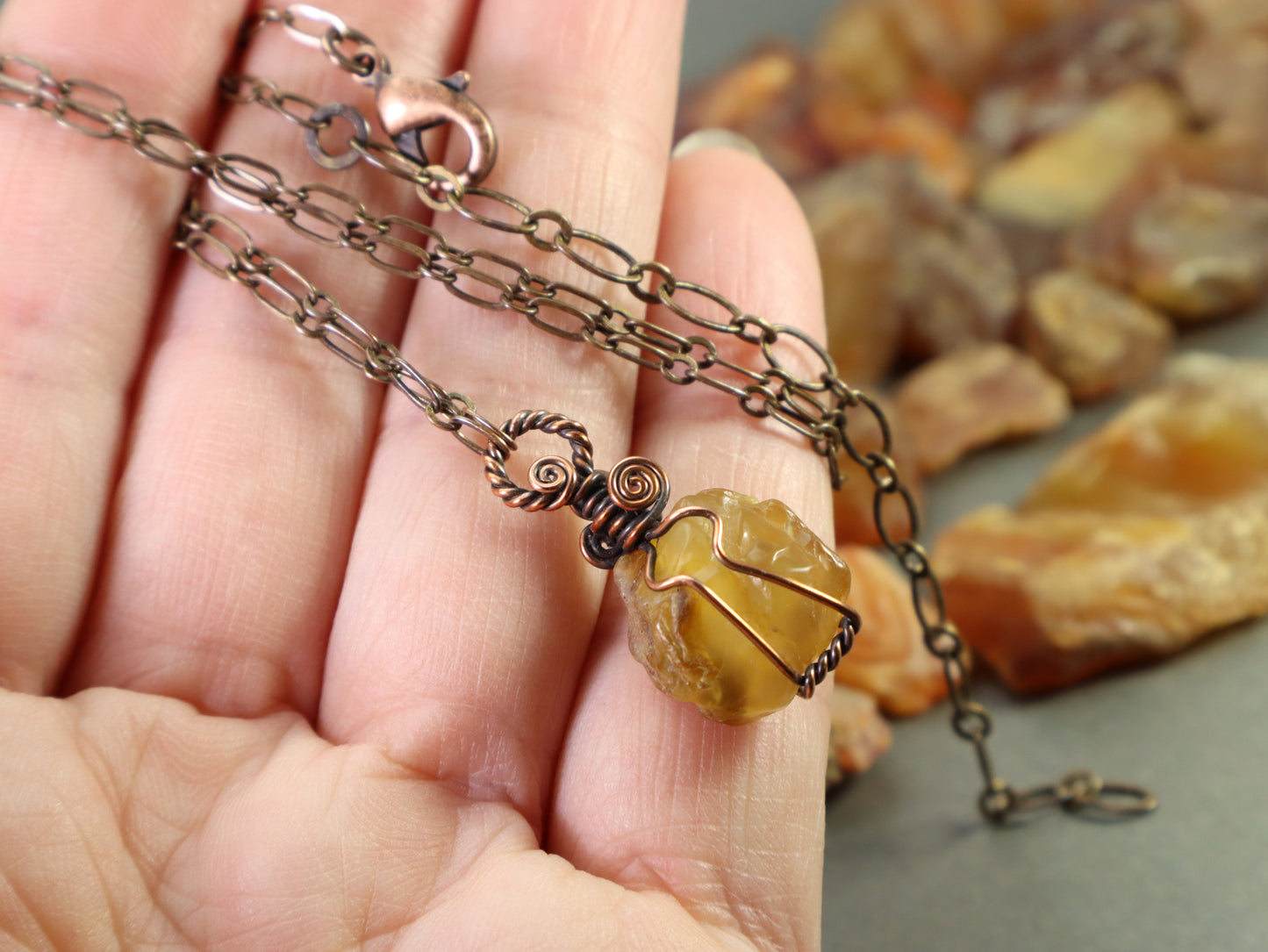 Wire wrapped carnelian agate pendant shown in hand for size reference