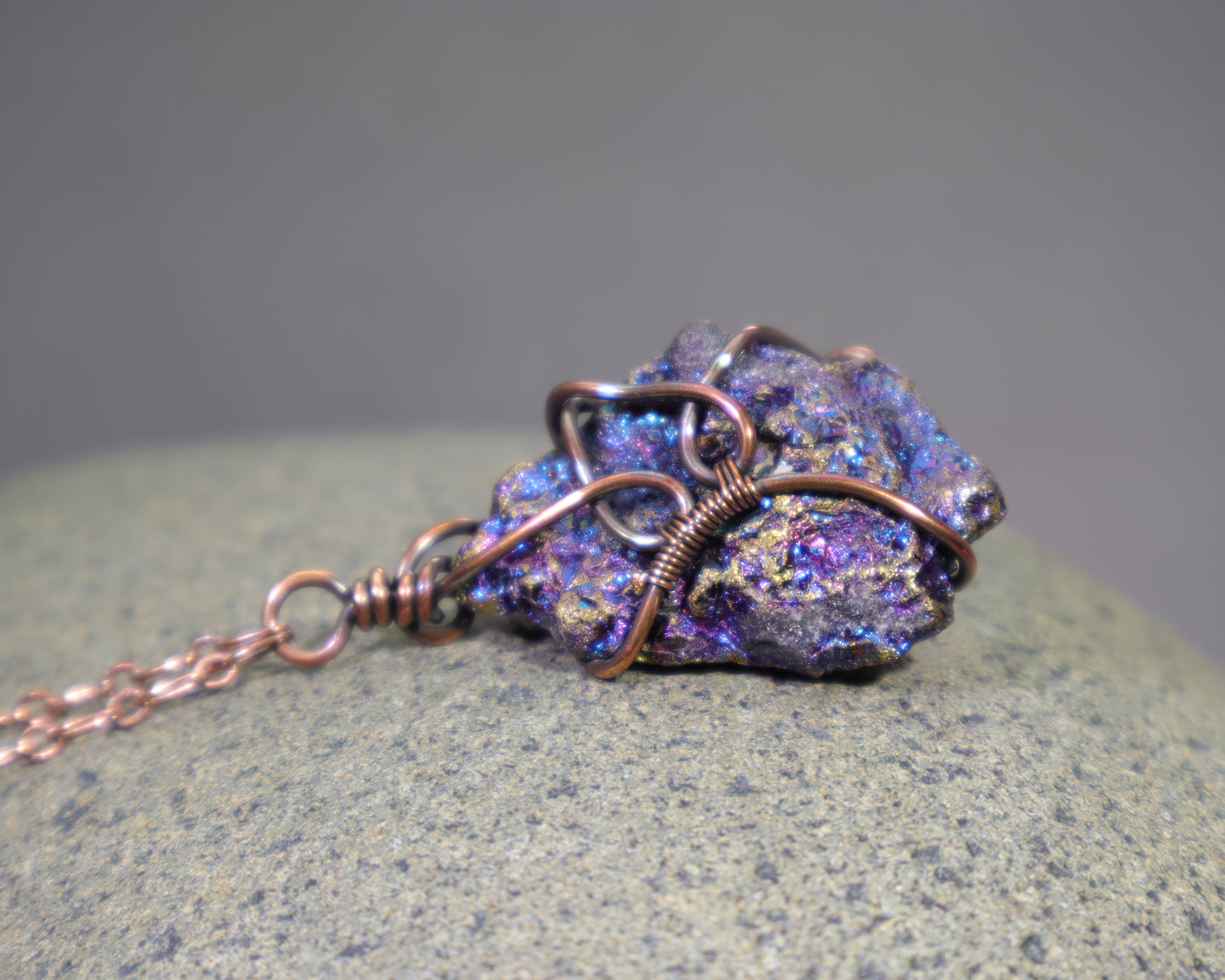 A bornite chalcopyrite specimen wire wrapped pendant necklace with antiqued copper wire and an adjustable copper chain.