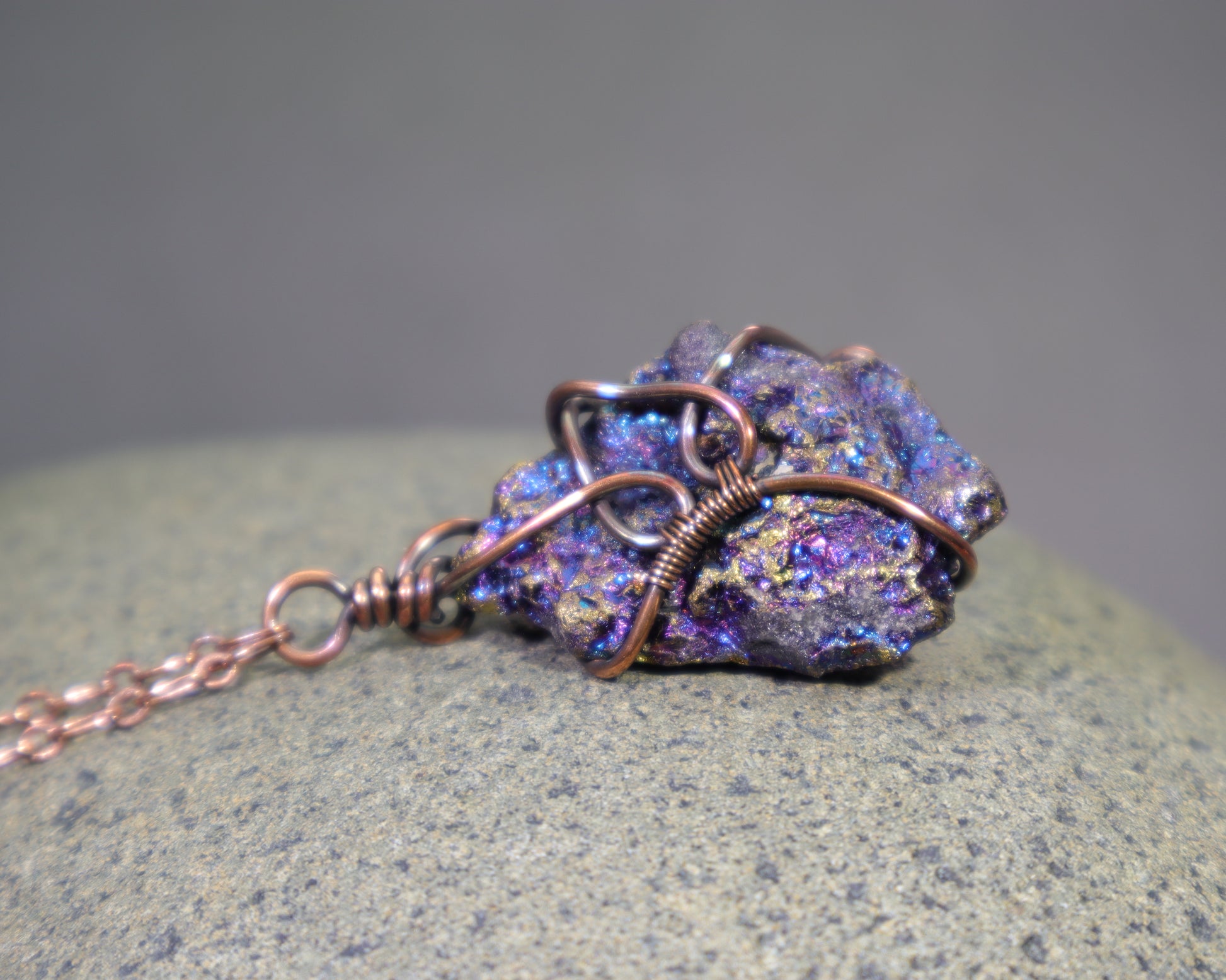 A bornite chalcopyrite specimen wire wrapped pendant necklace with antiqued copper wire and an adjustable copper chain.