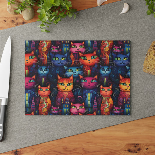 Cat glass cutting board styled on a countertop with a knife and fresh herbs. Small size is 8 x 11 inches.