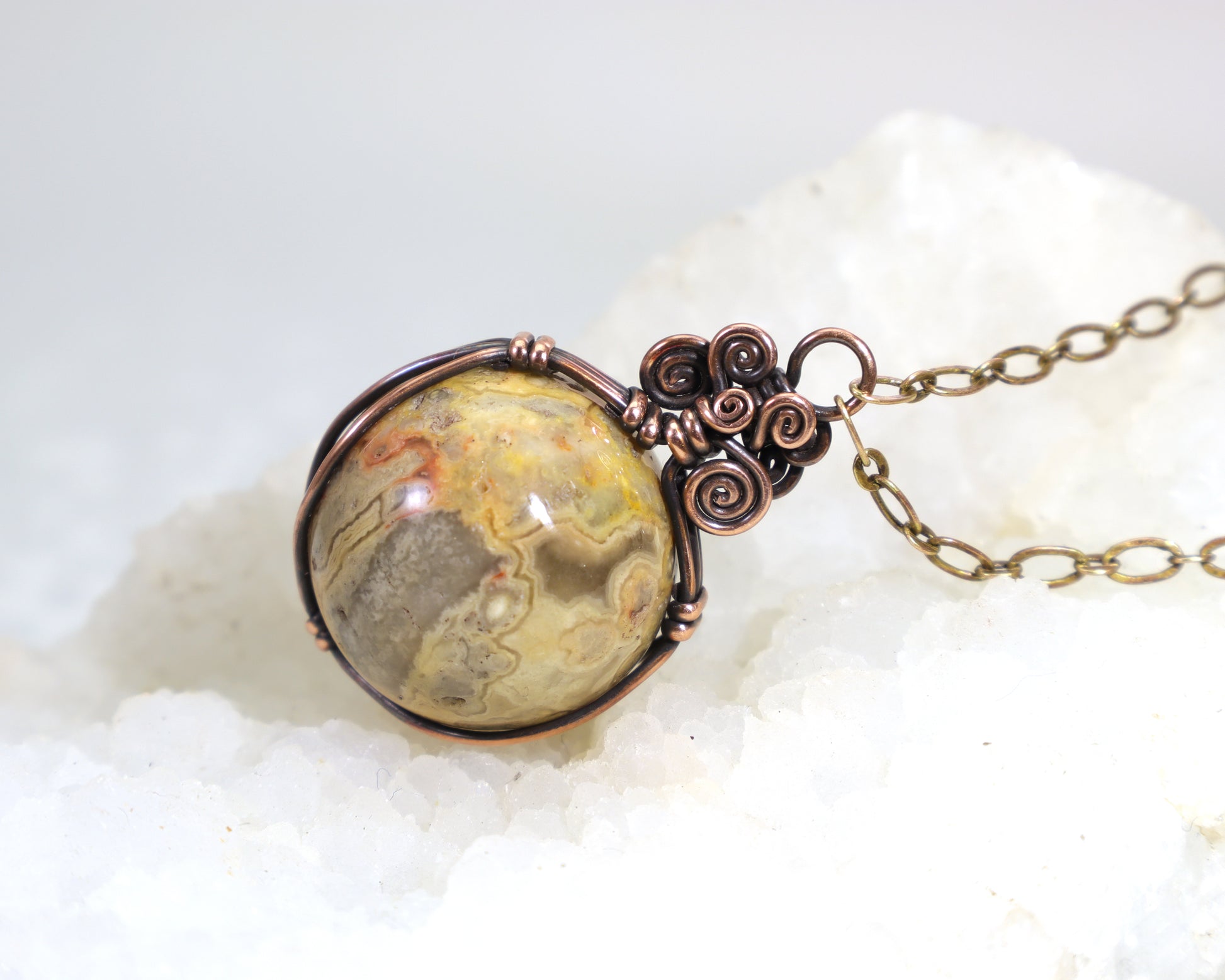 Yellow crazy lace agate gemstone sphere pendant with copper wirework