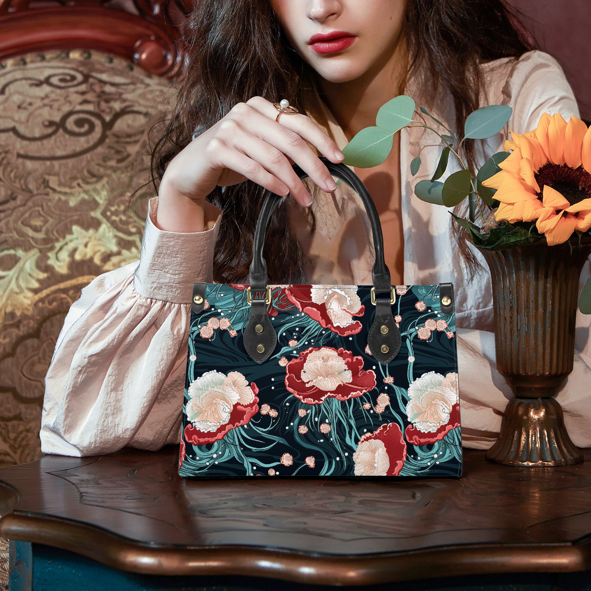 Woman holding a floral embroidered handbag on a wooden table with a vase of flowers in the background.