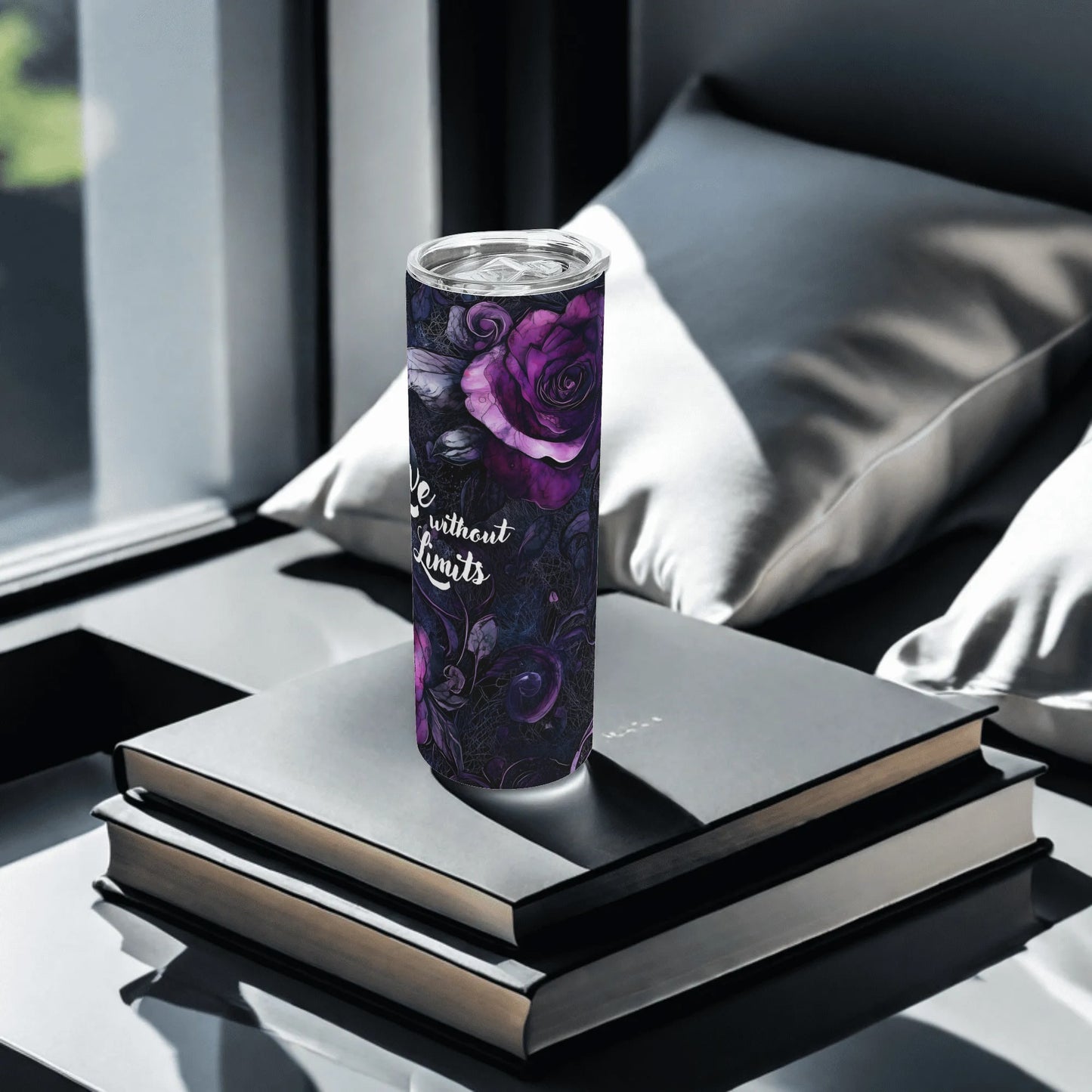 Tumbler with floral design and text on a stack of books by a window