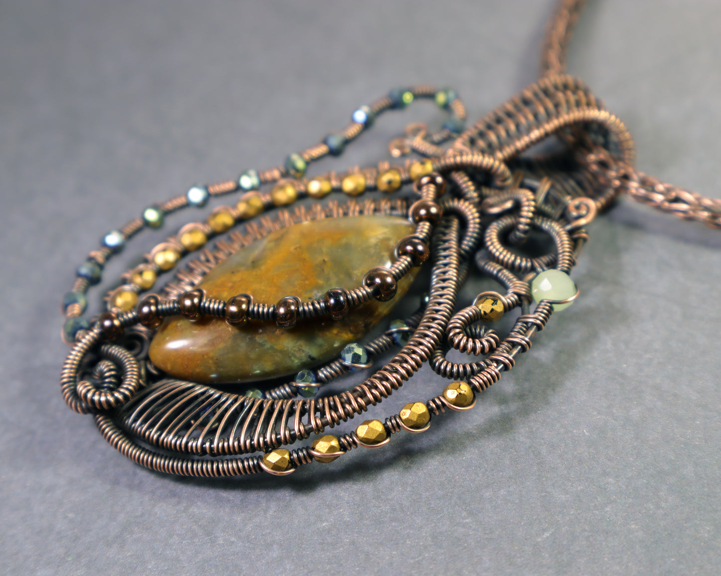 Music themed artisan pendant in oxidized copper with moss agate and sparkly crytstal accents in green and golds.