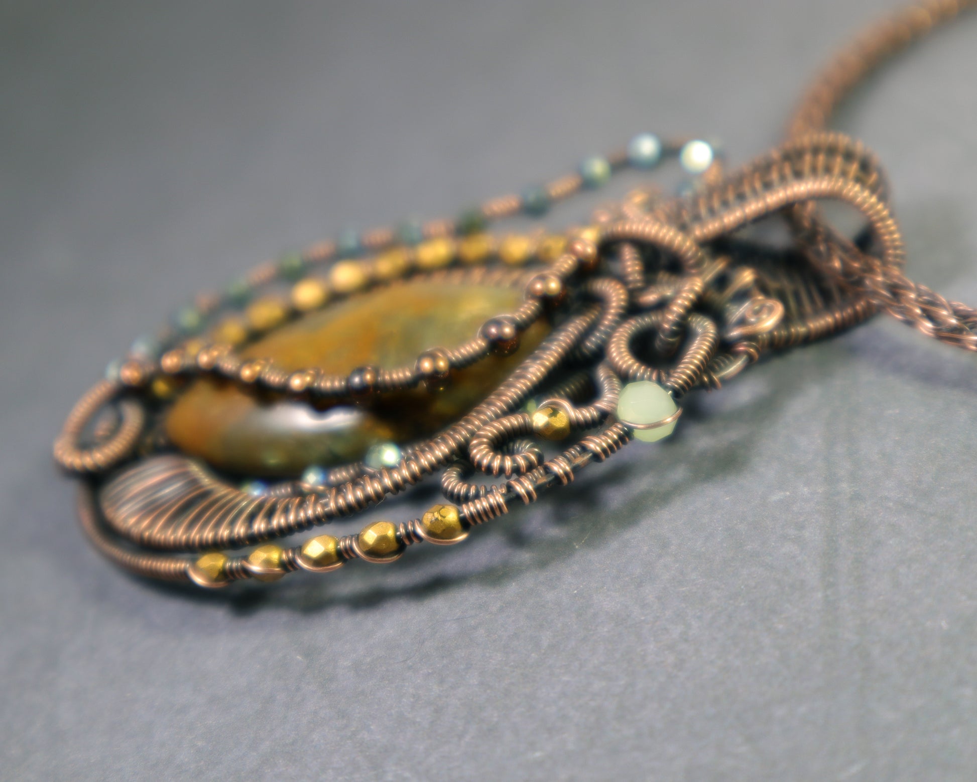 Copper wire wrapped moss agate pendant with decorative beadwork