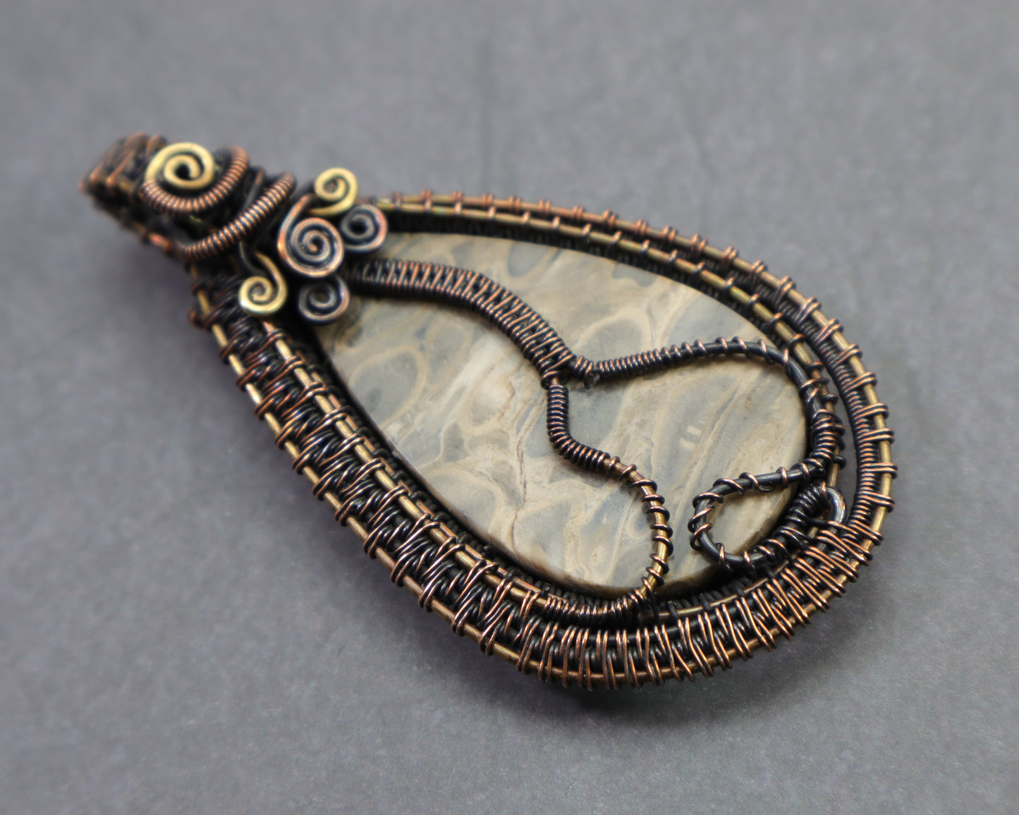 Double sided petrified palmwood pendant with decorative wire design