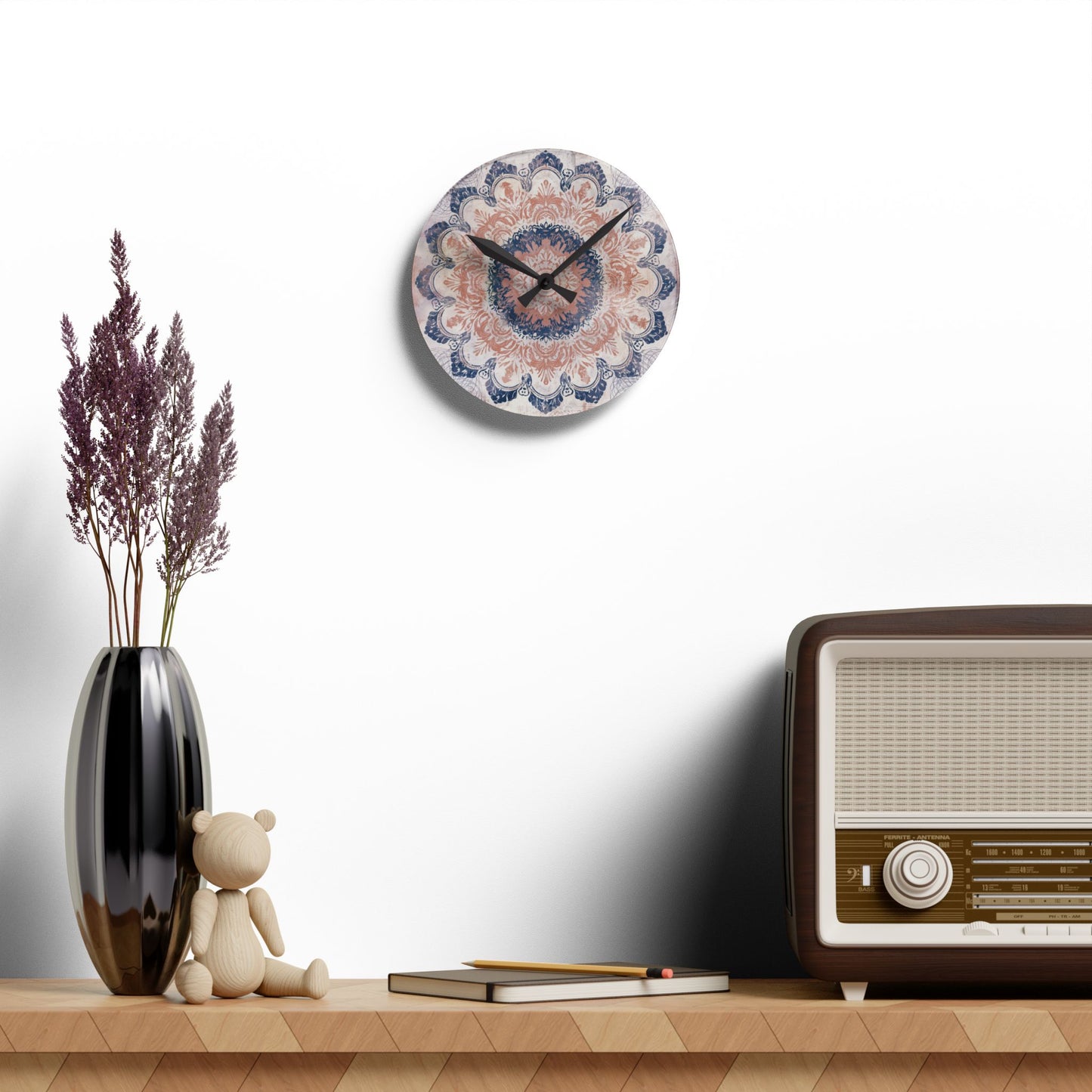 Small round acrylic wall clock with boho mandala design above shelf and vintage radio