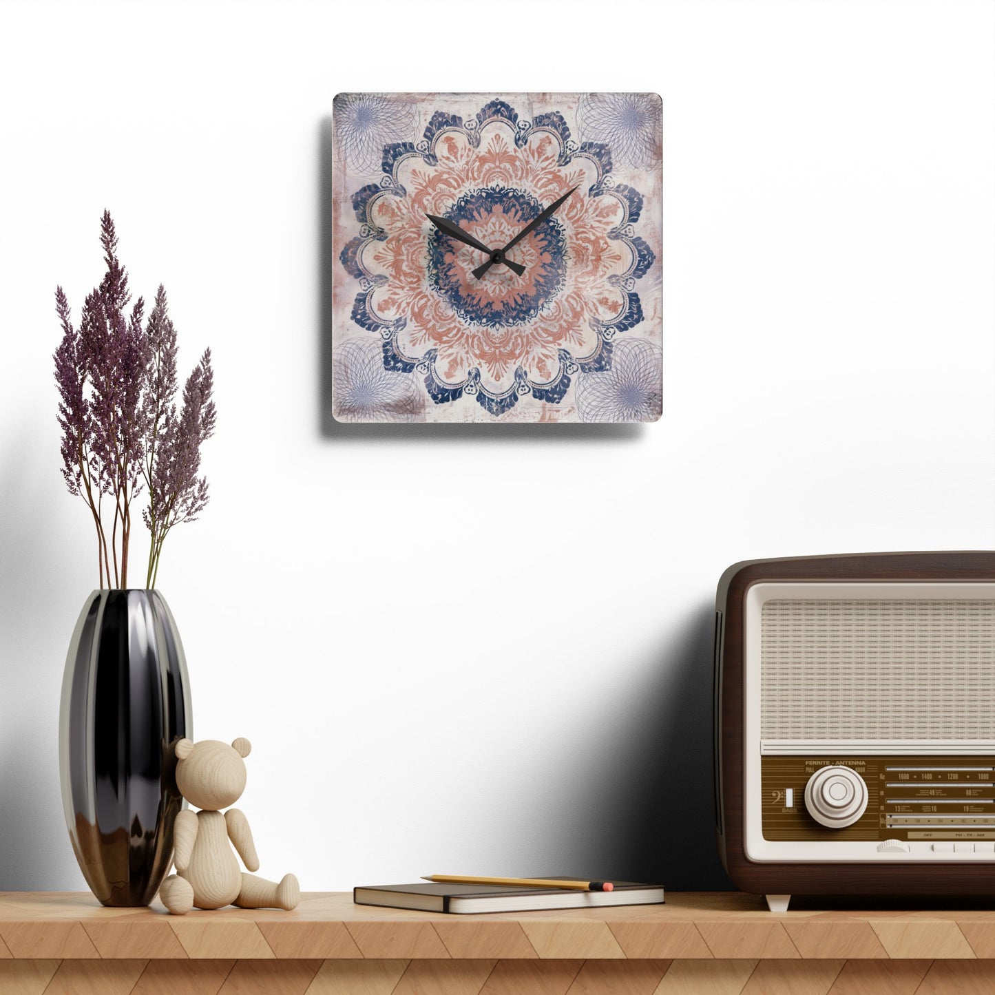 Rose pink and navy blue mandala wall clock displayed above shelf with vintage radio and vase