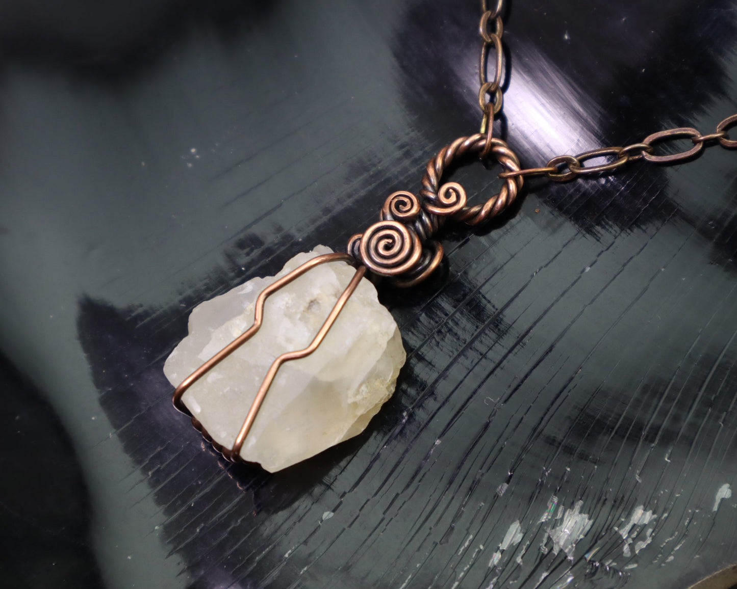 Raw white moonstone crystal pendant wrapped in antiqued copper wire