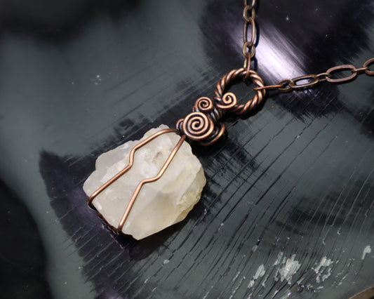 Raw white moonstone crystal pendant wrapped in antiqued copper wire