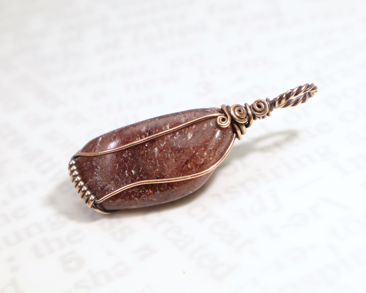 Back view of red aventurine gemstone pendant wrapped in oxidized copper