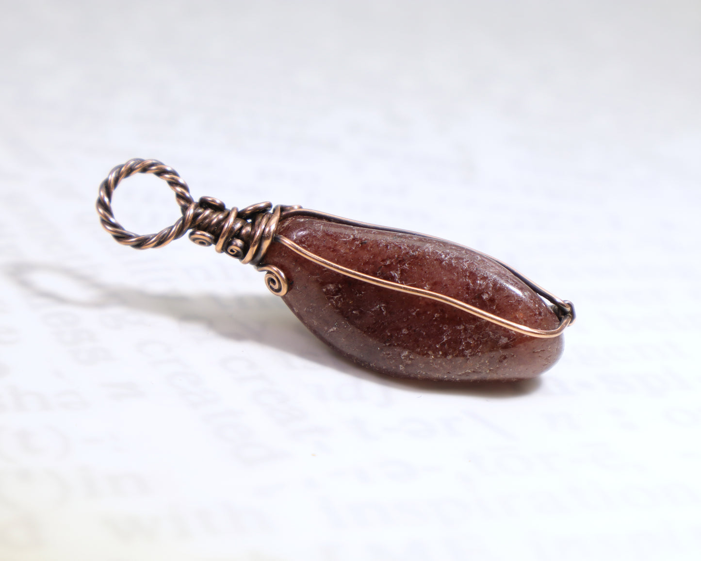 Side view of Artisan handmade red aventurine gemstone jewelry in copper, front is facing down.