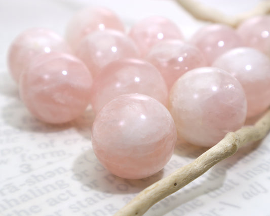 Close-up of rose quartz crystal balls on a white background