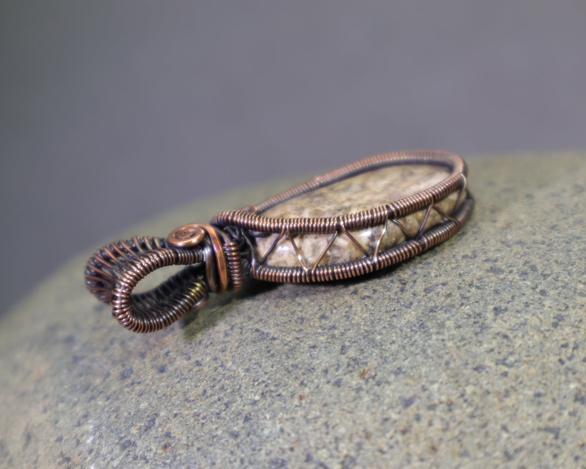 Natural jasper cabochon pendant with detailed copper wire weaving