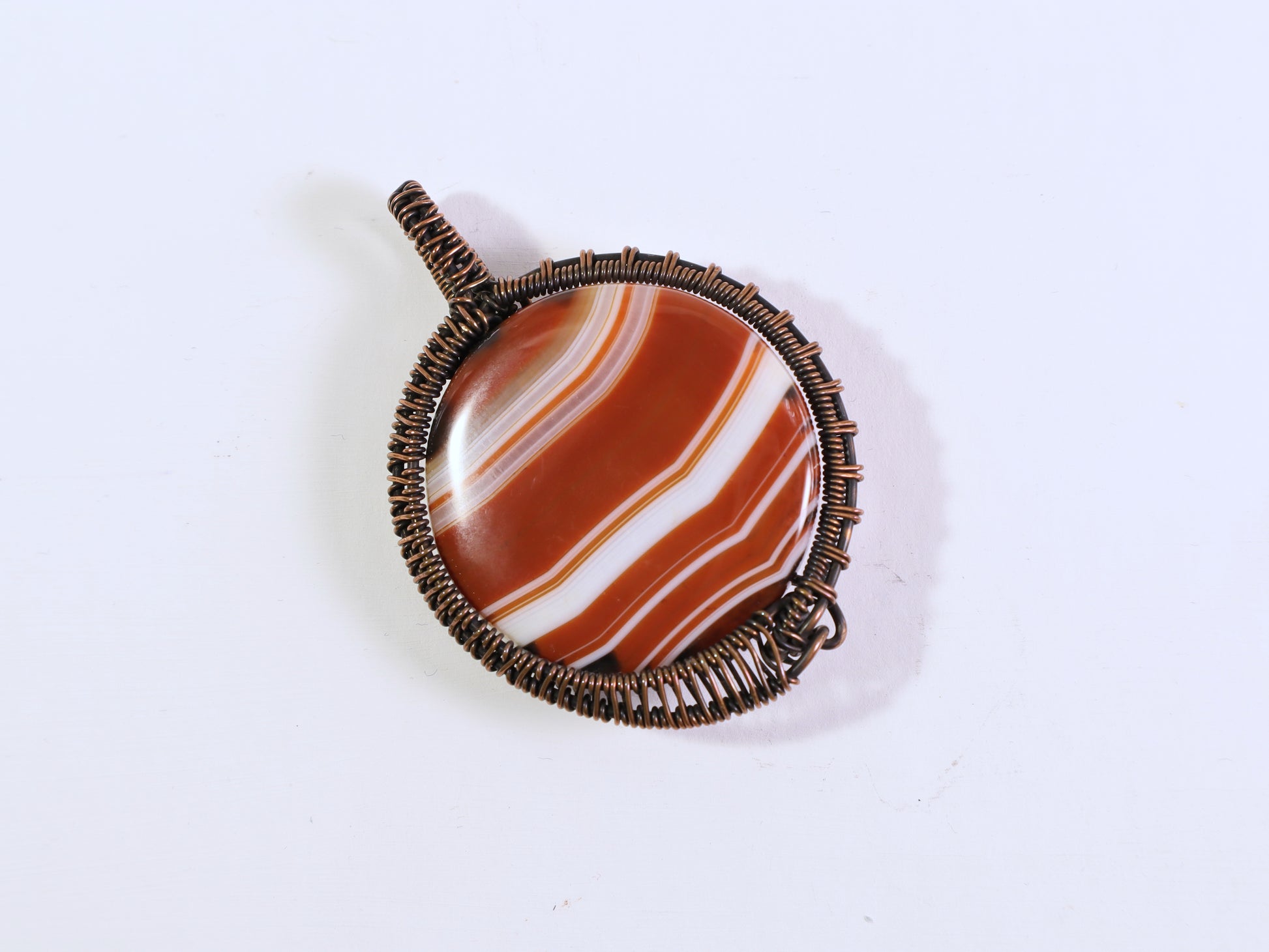 Handmade sardonyx gemstone pendant wrapped in oxidized copper wire