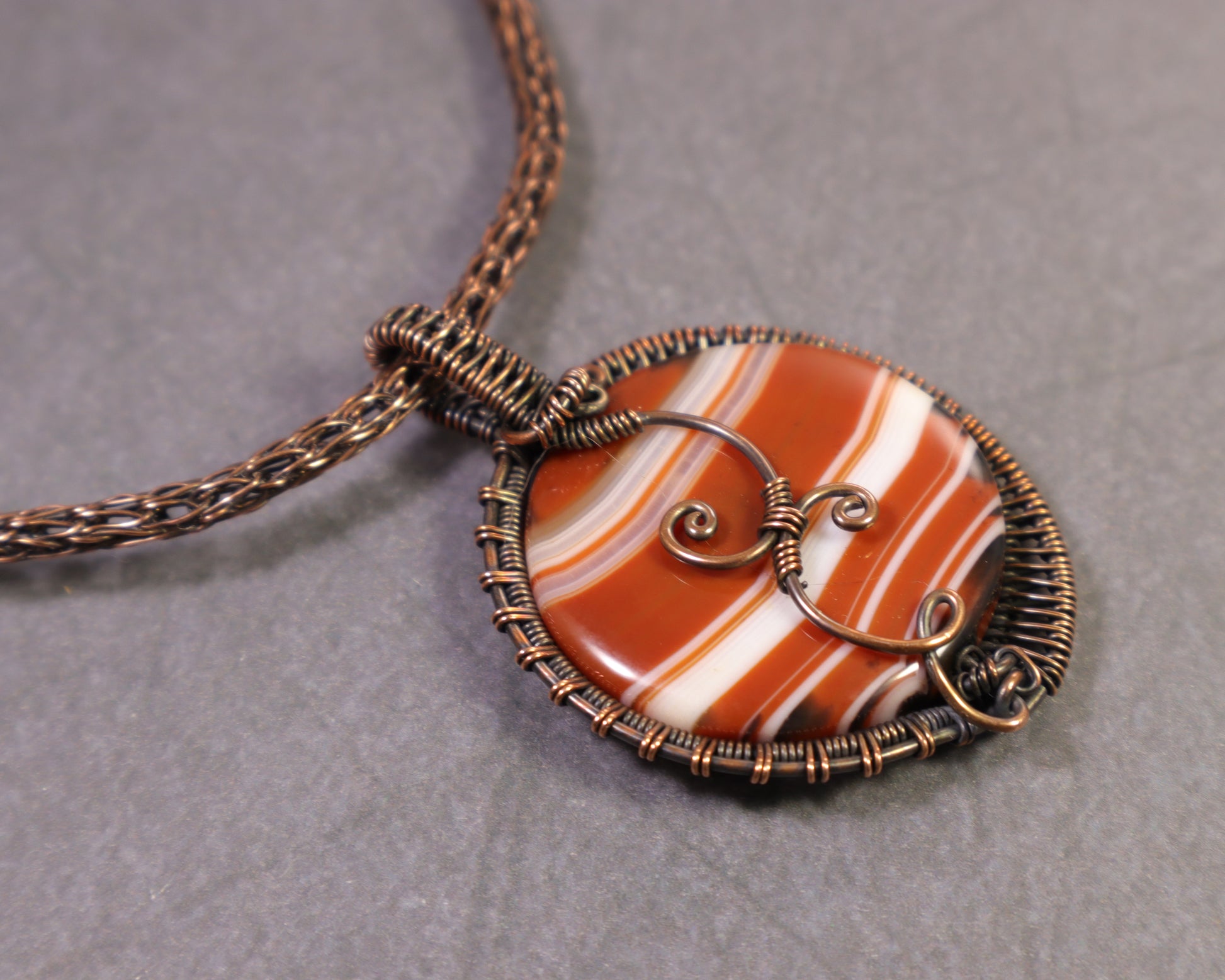 Natural banded sardonyx pendant with orange white and brown agate layers