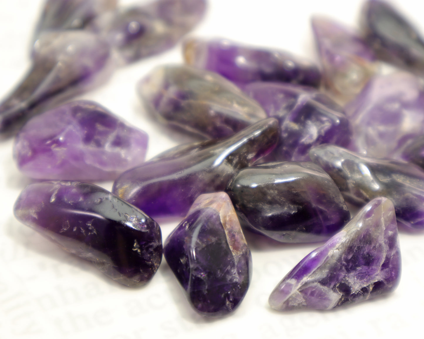 Close-up of dark purple amethyst crystal on a white background