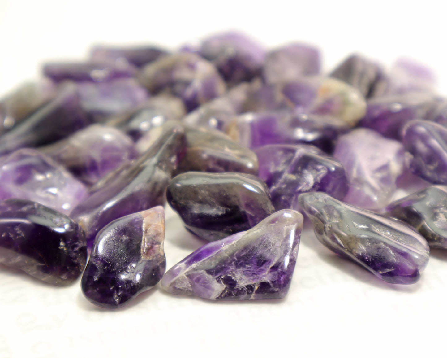 Close-up of dark amethyst tumble stones showing smoky zones