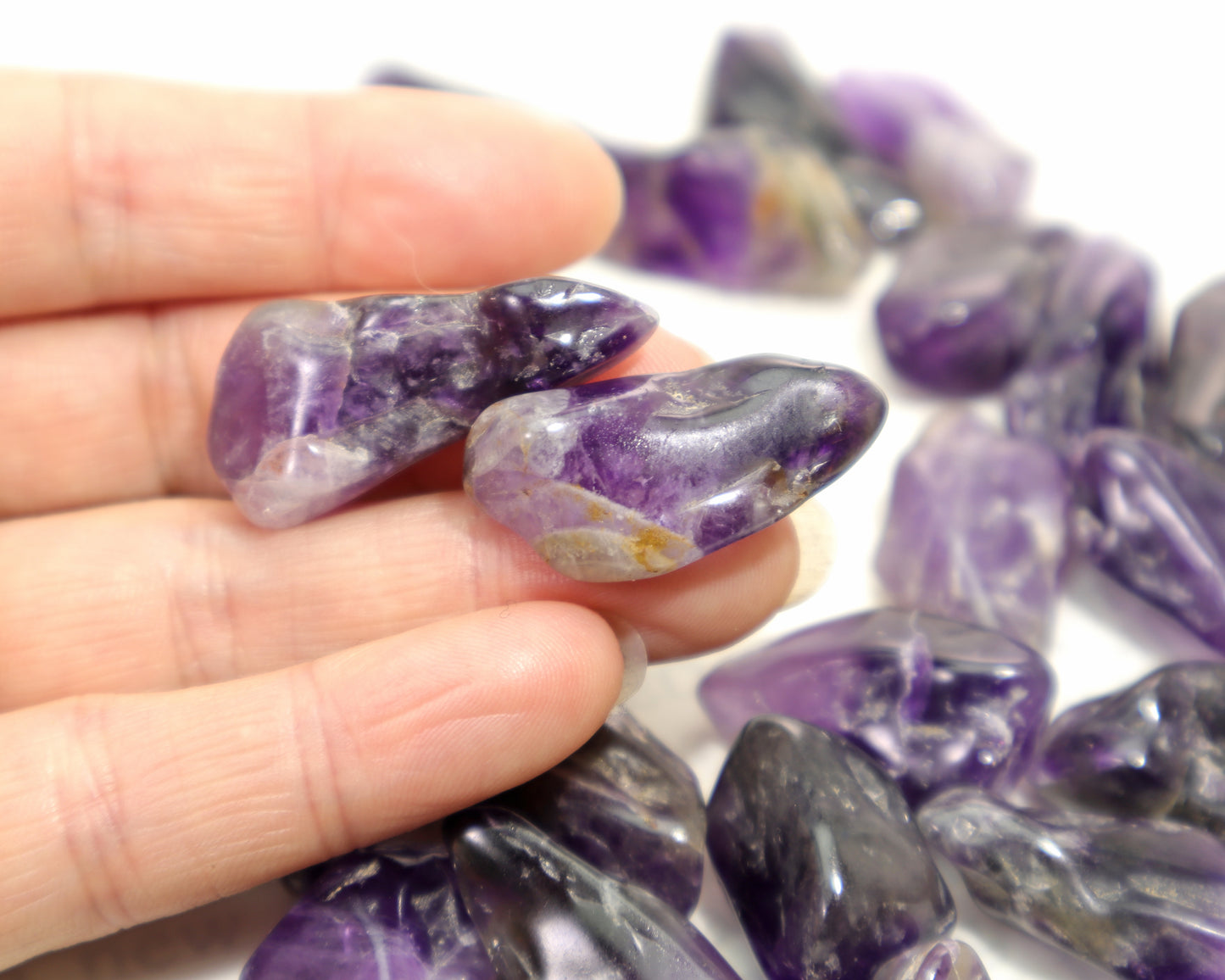 Hand holding amethyst pocket stones polished natural quartz