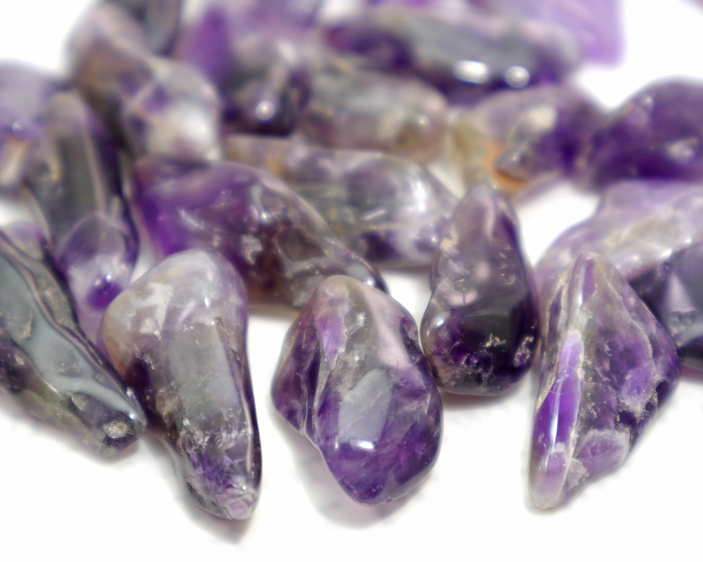 Close up of natural amethyst tumbled stones with smoky inclusions